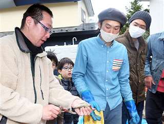 魚をさばいてみせる山本さん（左）と菊地さん（中央）