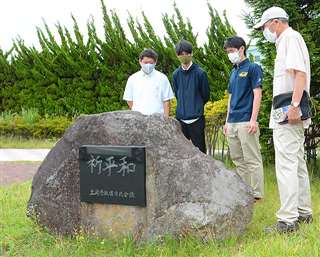 光沼近隣公園の慰霊碑を見つめる山手教諭（右から２人目）と生徒ら